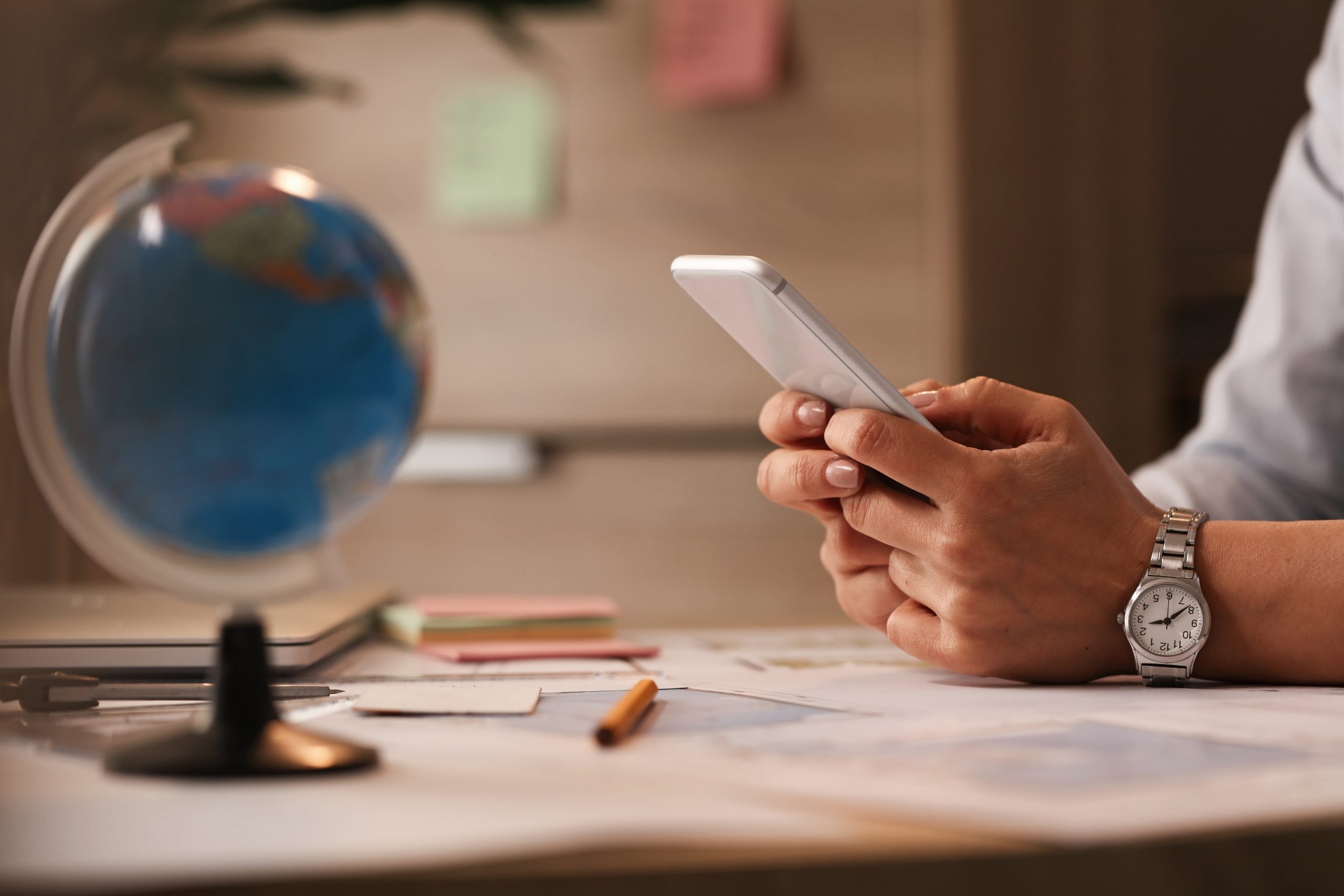 close-up-businesswoman-using-smart-phone-typing-message-office-scaled.jpg